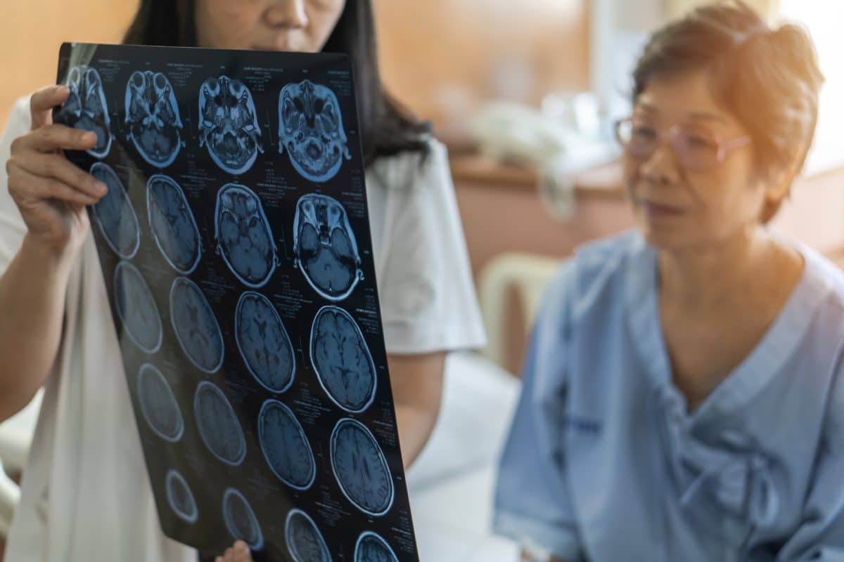 A woman in Louisiana looks over x-ray scans of her brain injury with a doctor.