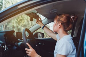 woman adjusting rearview mirror
