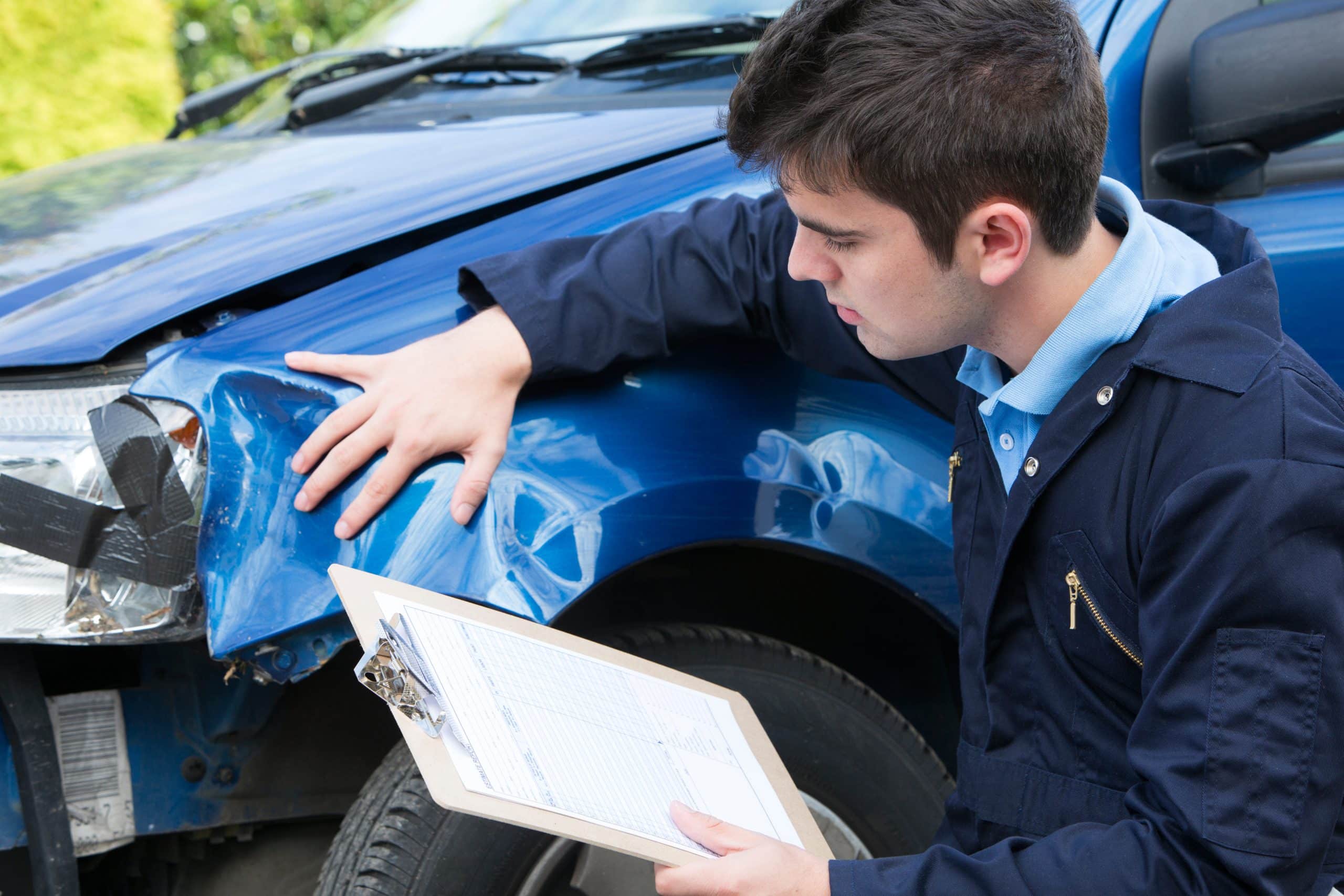 insurance adjuster inspecting damage after a car accident